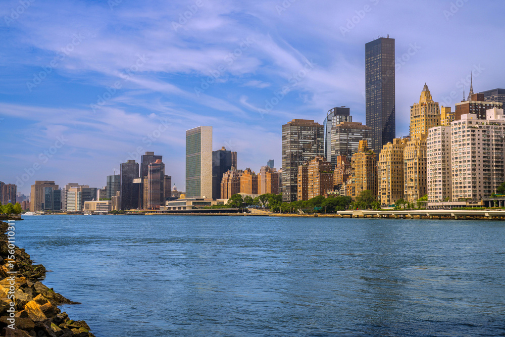 Fototapeta premium New York City skyline and Upper East Side buildings and skyscrapers as seen from Roosevelt Island at golden hour over the East River, USA