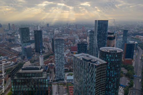 Aerial image of Manchester cityscape in the morning with sun-rays breaking through the clouds 