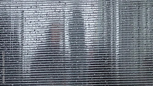 Silhouettes of people in a blurred background through glass, rain. 