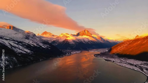 The perfect mountain aerial shot in sunset. Majestic sunrise over snow-capped mountains with clouds in the valleys
