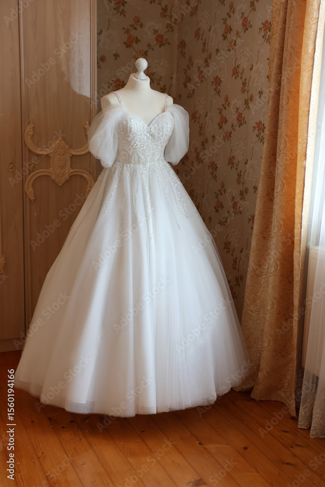 Beautiful white wedding dress on a mannequin in the room. Beautiful white wedding dress on a mannequin in the room.