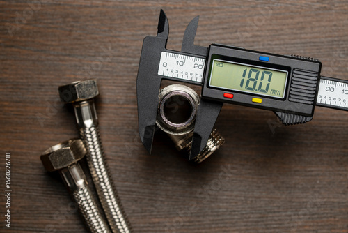 Measuring the diameter of plumbing adapters with an electronic digital caliper, closeup, top view. Plumbing repair concept