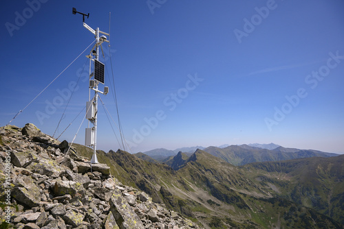 Automated weather station collecting atmospheric data on a remote mountain peak, contributing to climate research and forecasting