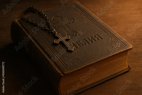 Orthodox christian bible with metal cross necklace on wooden table illuminated by warm light symbolizing faith and tradition