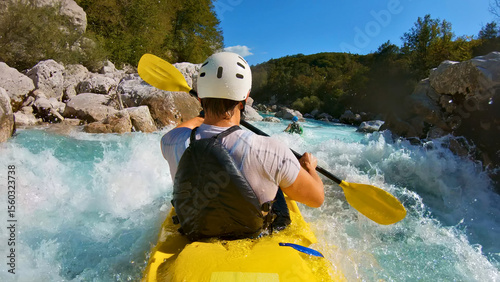 A thrilling kayaking adventure unfolds as a person navigates a yellow kayak through a rapid river, showcasing their skill and determination. A close-up shot captures the kayaker's white helmet and.