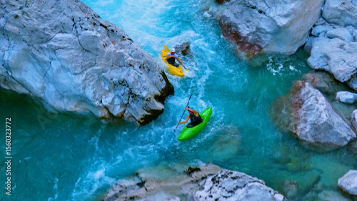 Bild auf Leinwand A thrilling aerial view showcases two kayakers navigating a narrow, fast-flowing river between large rocks