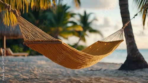Cozy Yellow Hammock Strung Between Palm Trees on Serene Beach at Sunset