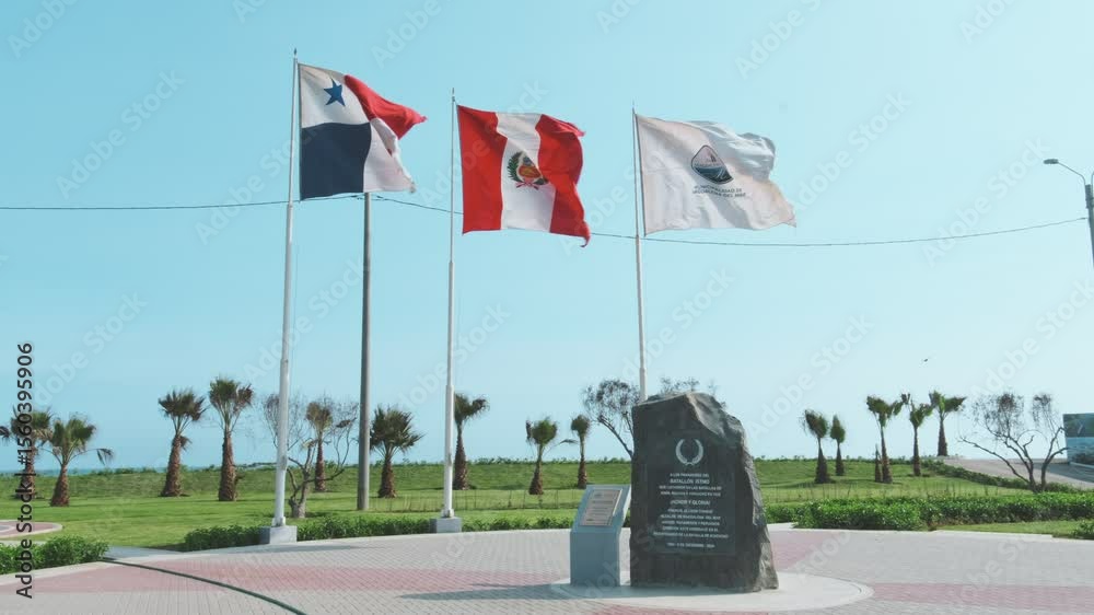 Two panamanian flags waving in the wind at parque ismo de panama, near the cinta costera, with the ocean in the background