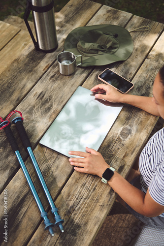 Young Adventurer Using Digital Tablet Outdoors on Rustic Wooden Table