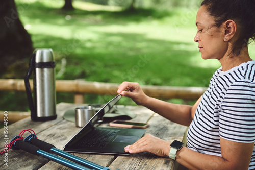 Woman Enjoying Remote Work Outdoors in a Scenic Park Setting