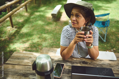 Smiling Woman Relaxing Outdoor With a Hot Drink in a Camping Setting