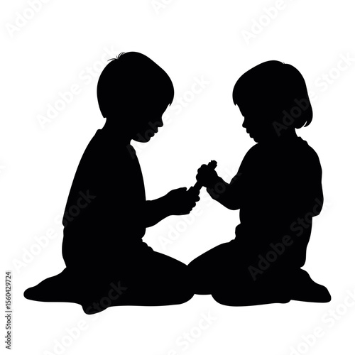 Children playing together while sitting on the floor in silhouette  