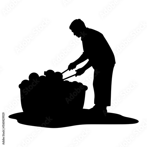 Man using tongs to serve food from large bowl in silhouette  