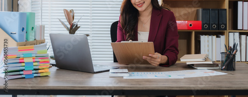 Quadro em tela Office Task and Focused Thought: A focused individual works at a desk laden with paperwork, embodying dedication and concentration as they assess information using technology
