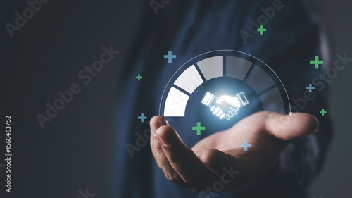 Hand holding glowing handshake icon with progress graphic, representing trusted partner, business relationship, collaboration, reliability, and long-term success.