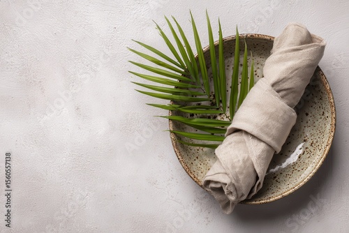 Rolled Neutral Linen Napkin on Plate with Green Leaf Accent