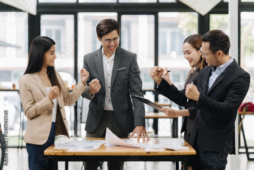 Team Victory in the Office: Capturing the dynamic essence of a contemporary office setting, where a diverse group of professionals celebrates a moment of triumph and unity.