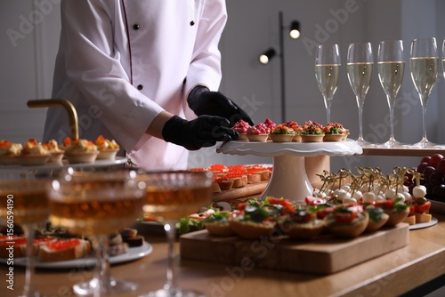 Chef arranging appetizers on buffet table, closeup