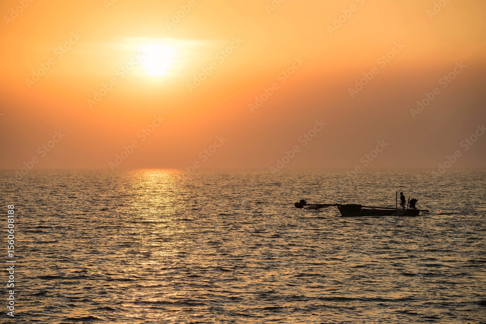 Fototapeta premium Silhouette fisherman sail motor boat on sea to fishing at sunset