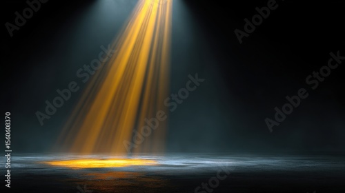 Radiant light beams penetrate the darkness and illuminate a misty surface below  creating a dramatic atmosphere