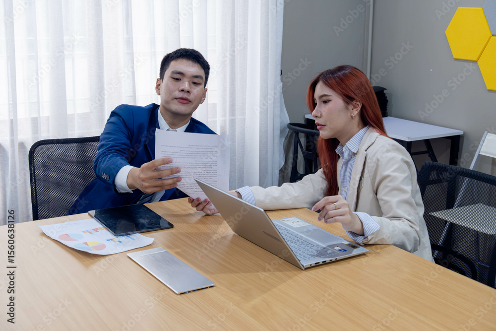 Colleagues discussing project details in a modern office setting during the afternoon hours Colleagues discussing project details in a modern office setting during the afternoon hours