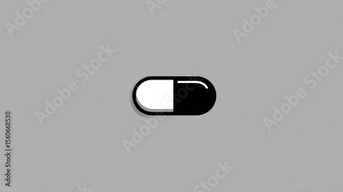 Simple black and white capsule with soft shadow isolated against a gray background