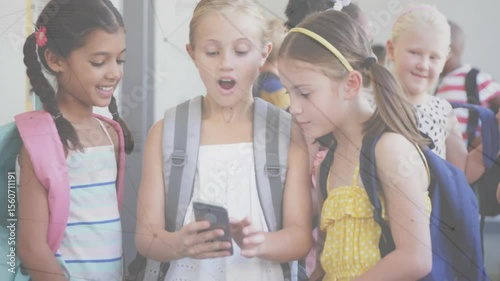 School friends leaning over smartphone screen tapping and revealing educational content in corridor