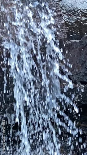 A turbulent waterfall with fast flowing water in a lush natural setting. Perfect for ecology, natural power, environment, travel and sustainability visualizations. slow motion,
