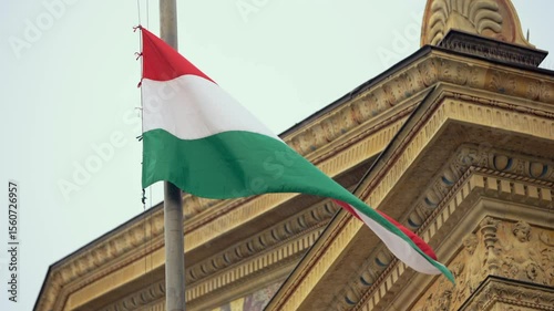 Slow motion of Hungarian flag gently fluttering near a historic building in Budapest, embodying the nation's architectural heritage and pride.