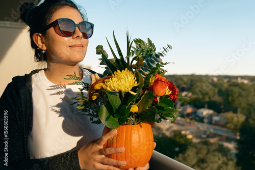 Happy woman enjoying finished fall flower pumpkin decor