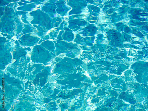 Sparkling blue water with flowing ripples under bright sunlight reflecting light