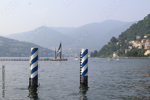 Dock and lakeside houses by Lake Como on an overcast day

