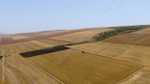 Drone footage of a combine harvesting wheat. Grain field