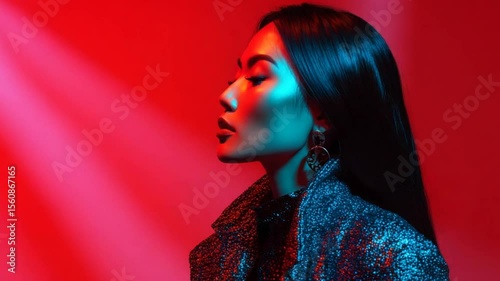 Portrait of a woman in side profile posing under colorful studio lighting