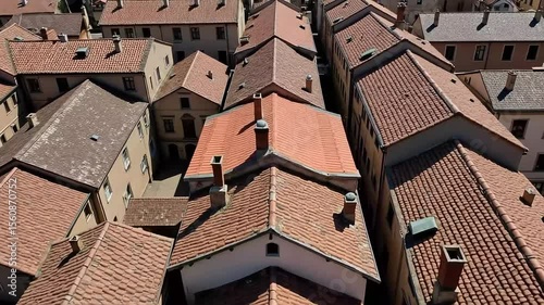 Charming aerial shot showcases a neighborhood of terracotta tile roofs and chimney tops in a European town.