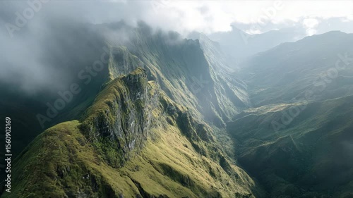 A breathtaking mountain landscape bathed in sunlight and shrouded in mist, creating a serene and majestic view.