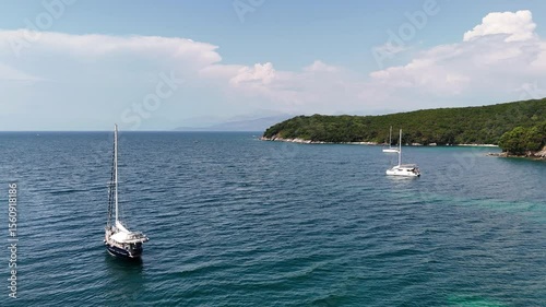 Flying near sailboats anchored in calm shallow waters in Corfu, Greece