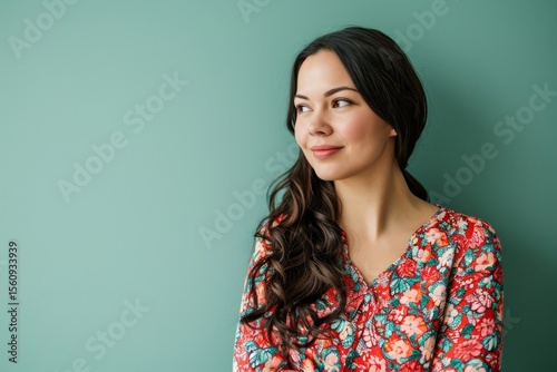 Portrait of a beautiful young woman looking away on a green background