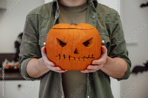 Closeup pf spooky halloween lantern in man's hand. Festive banner