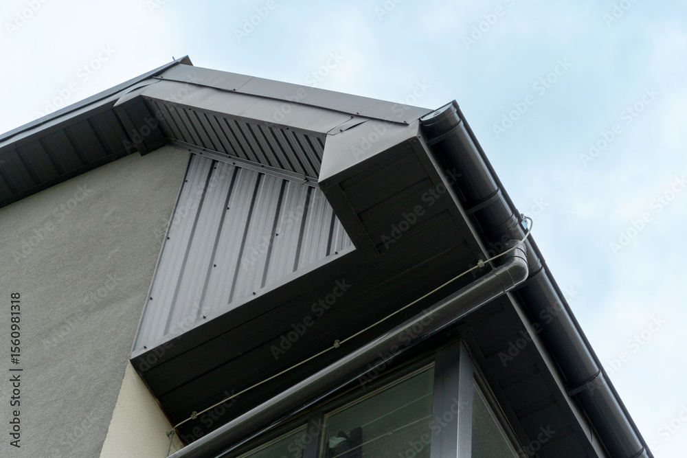 Fototapeta premium View of a contemporary building highlighting a sharp roofline, metallic siding, and large windows, showcasing modern architecture against a clear sky