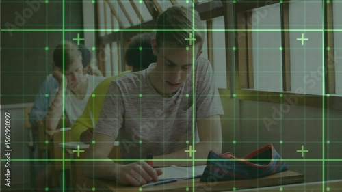 Teenage male student placing red pen and starting exam writing after green grid overlay settling