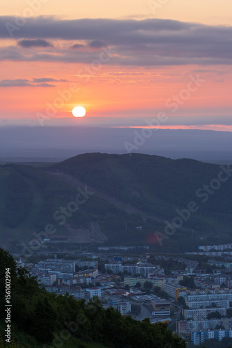 Morning cityscape. Top view of the buildings among the hills. Residential urban areas at sunrise. The sun rises over the mountains. City of Petropavlovsk-Kamchatsky, Kamchatka Krai, Far East of Russia