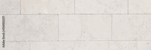 The texture of the wall, lined with light stone blocks. The polished surface of the masonry. Wide panoramic texture for background and design.