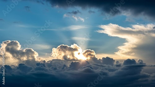 Golden Hour Sunset Clouds. Dark, dramatic clouds pierced by warm golden sunshine. Positive atmosphere, weather phenomenon, sky footage