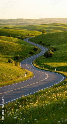 Winding Road Through Green Countryside Sunlit Hills Scenic Landscape