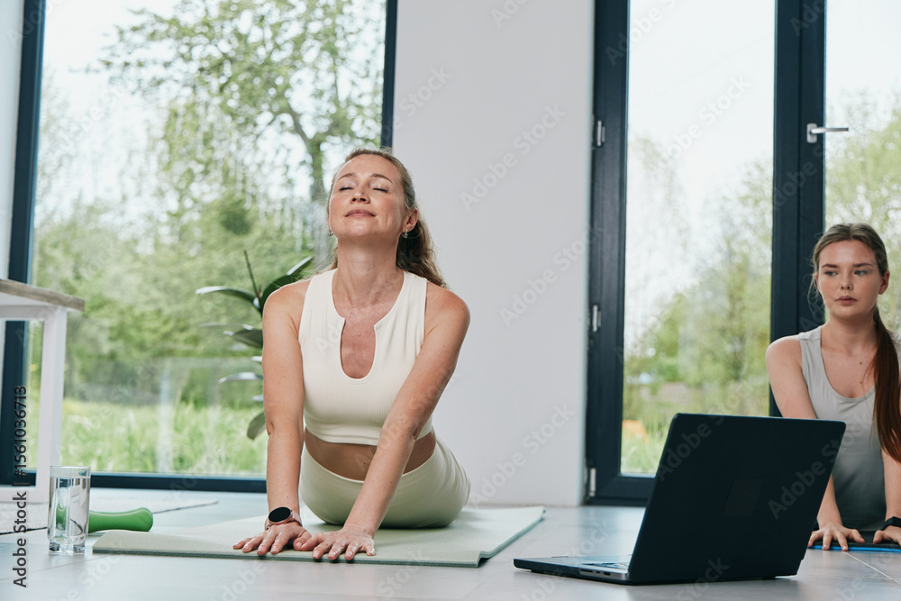 Obraz premium Middle age woman practicing yoga indoors, focused on wellbeing, health, and active lifestyle with natural light and modern home background