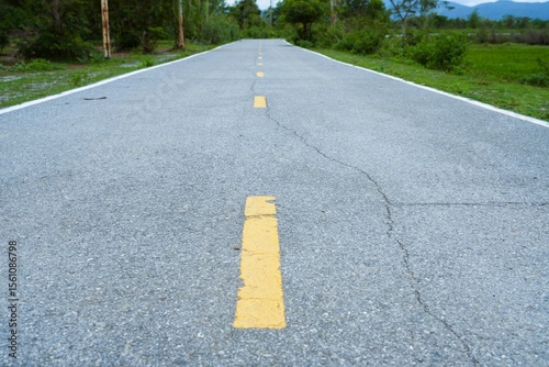 Yellow lines mark the rural asphalt road, a solitary route stretching through the landscape