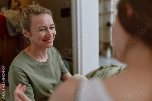 Smiling middle age woman enjoying wellness and healthy lifestyle, engaged in active community and fitness activities promoting longevity and wellbeing indoors.