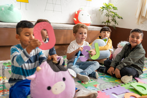 A diverse group of preschool kids playing with foam letters. Kindergarten education, playful learning, and building language skills in early childhood