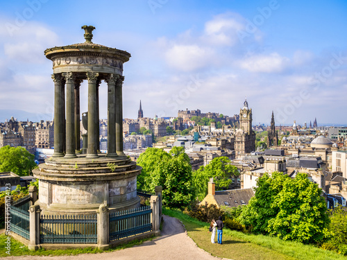 Edinburgh, Scotland - the Dugald Stewart Memorial on Calton Hill, with a view over Edinburgh to the castle. Young couple looking at view. photo